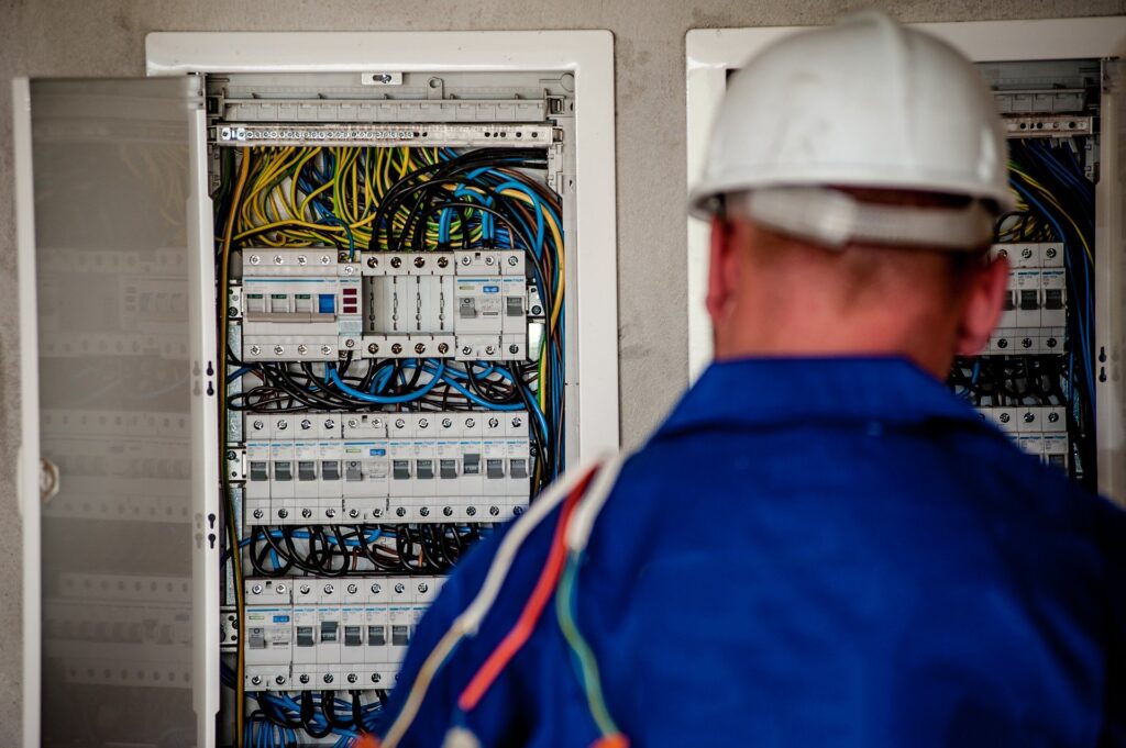 electrician working with electrical panel in the background